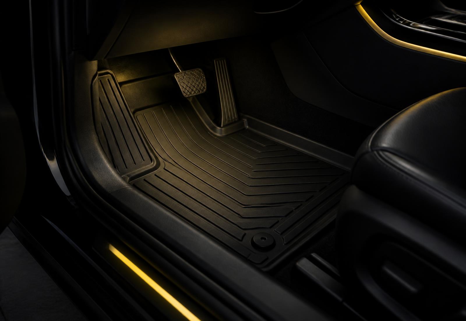 Tailored black rubber floor mat fitted in a car footwell